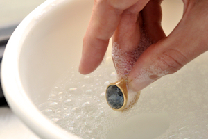 Bước 1: Hòa một ít nước rửa chén vào bát nước ấm từ 60 -70 độ C. Ngâm trang sức vào dung dịch trên trong 5 phút.
